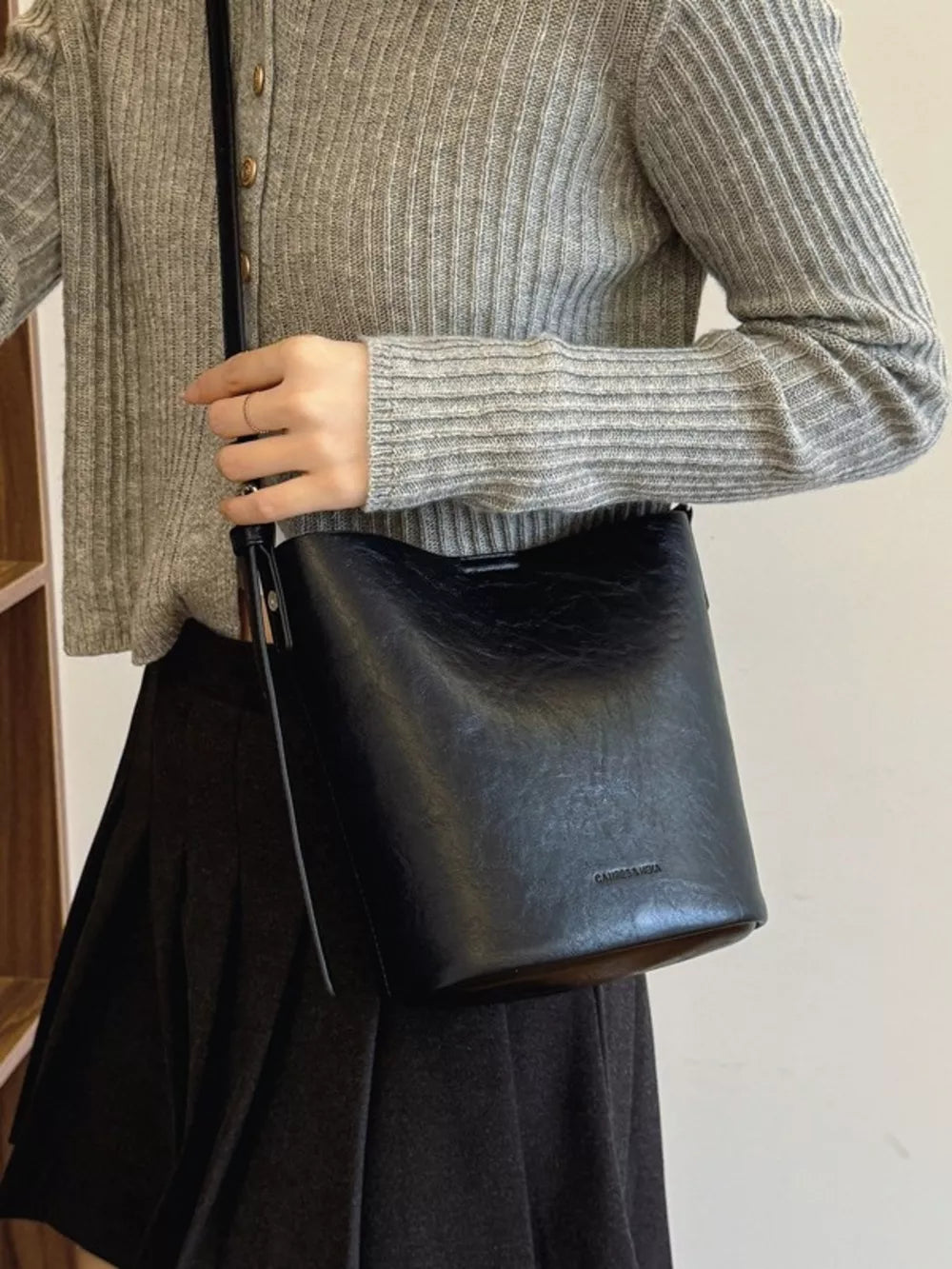 Black distressed vintage bucket crossbody bag with adjustable strap