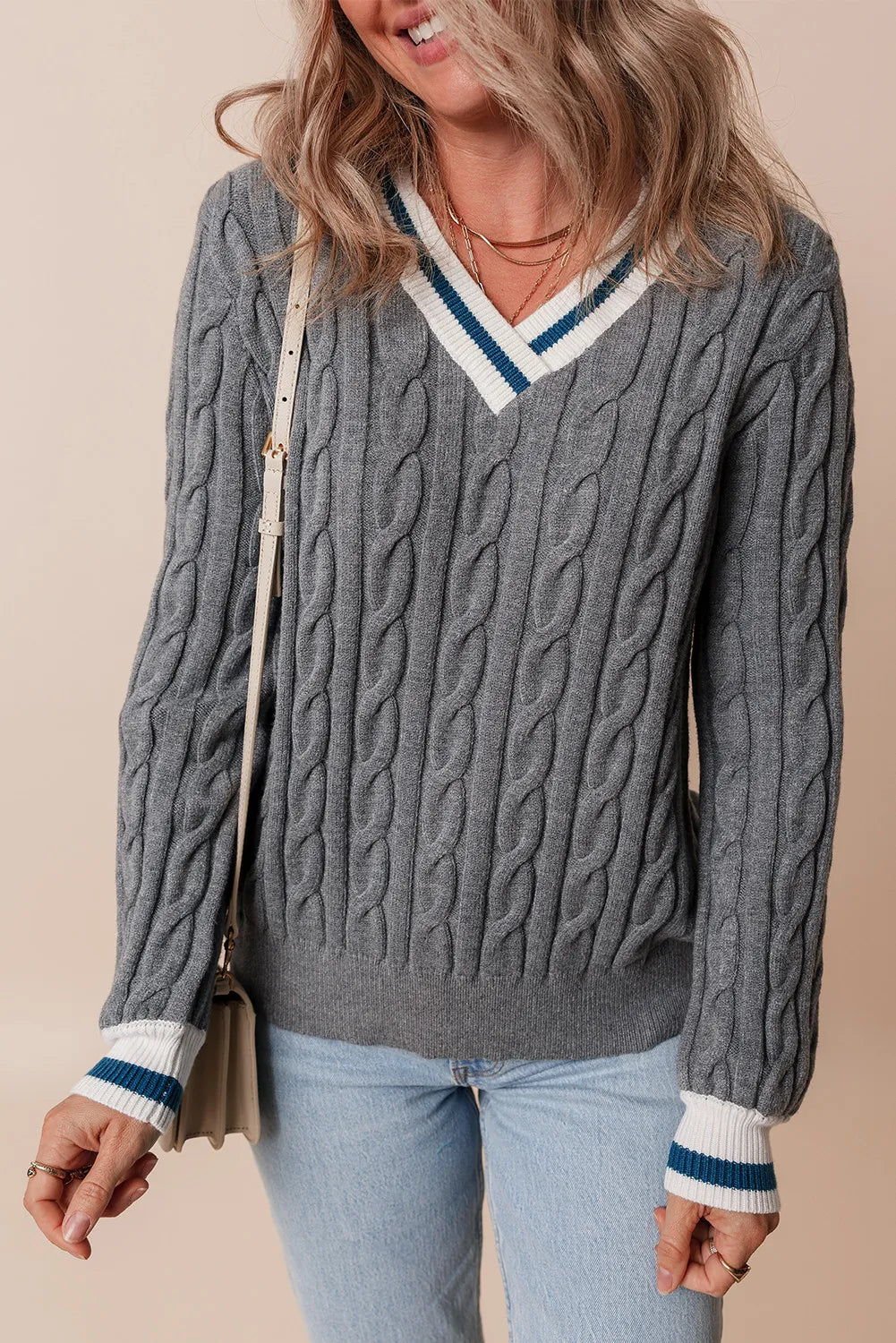 Cable knit sweater in dark gray with v-neck and varsity stripe trim on neckline and cuffs.