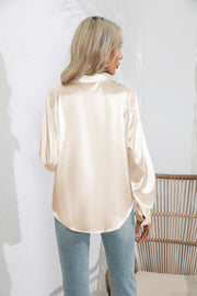 Glossy satin button-down blouse in tan with long sleeves and a relaxed fit.