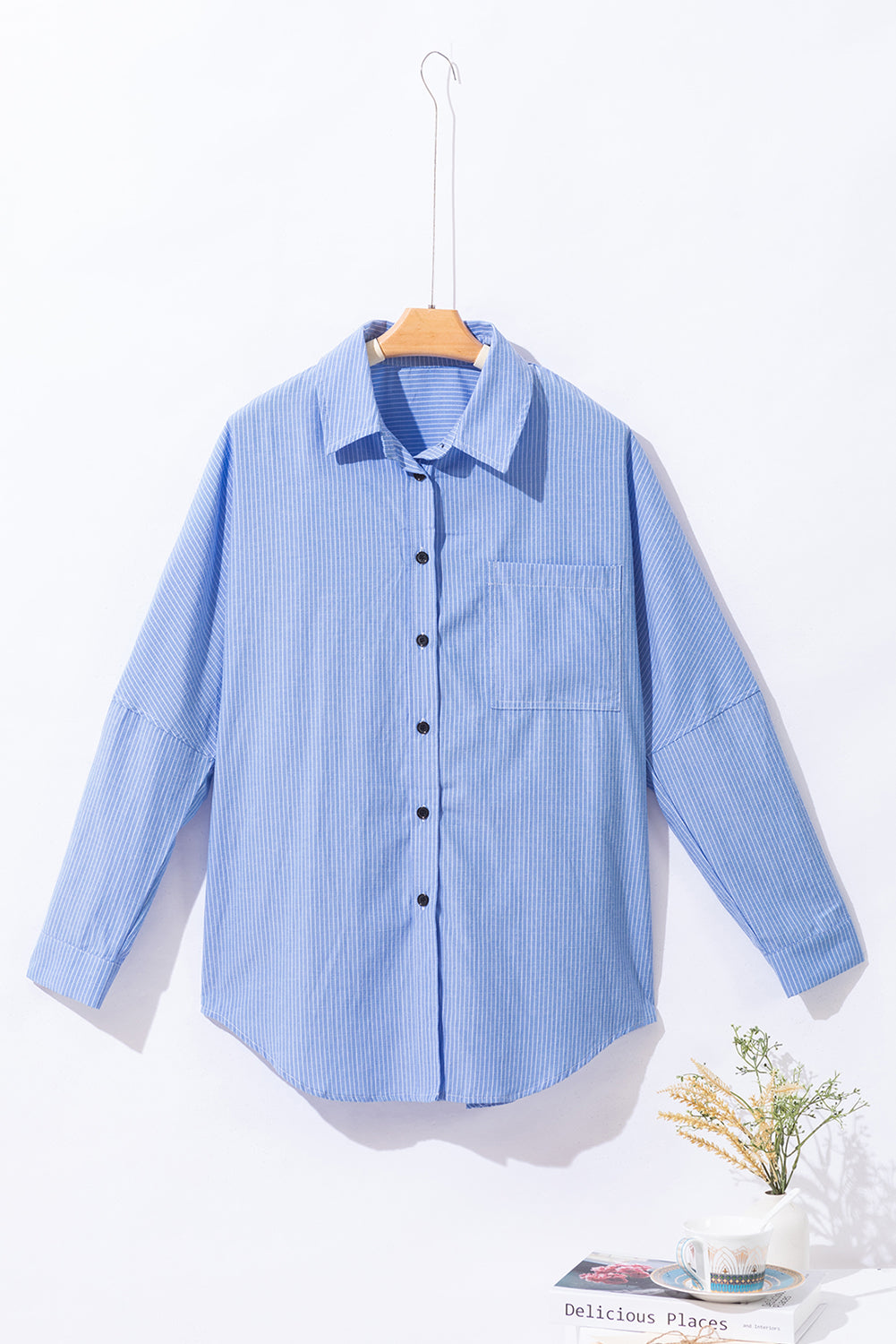 Light blue relaxed fit button-down shirt with vertical stripe texture and chest pocket.