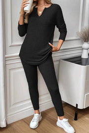 Black ribbed loungewear set with notched V-neck long sleeve top and leggings.