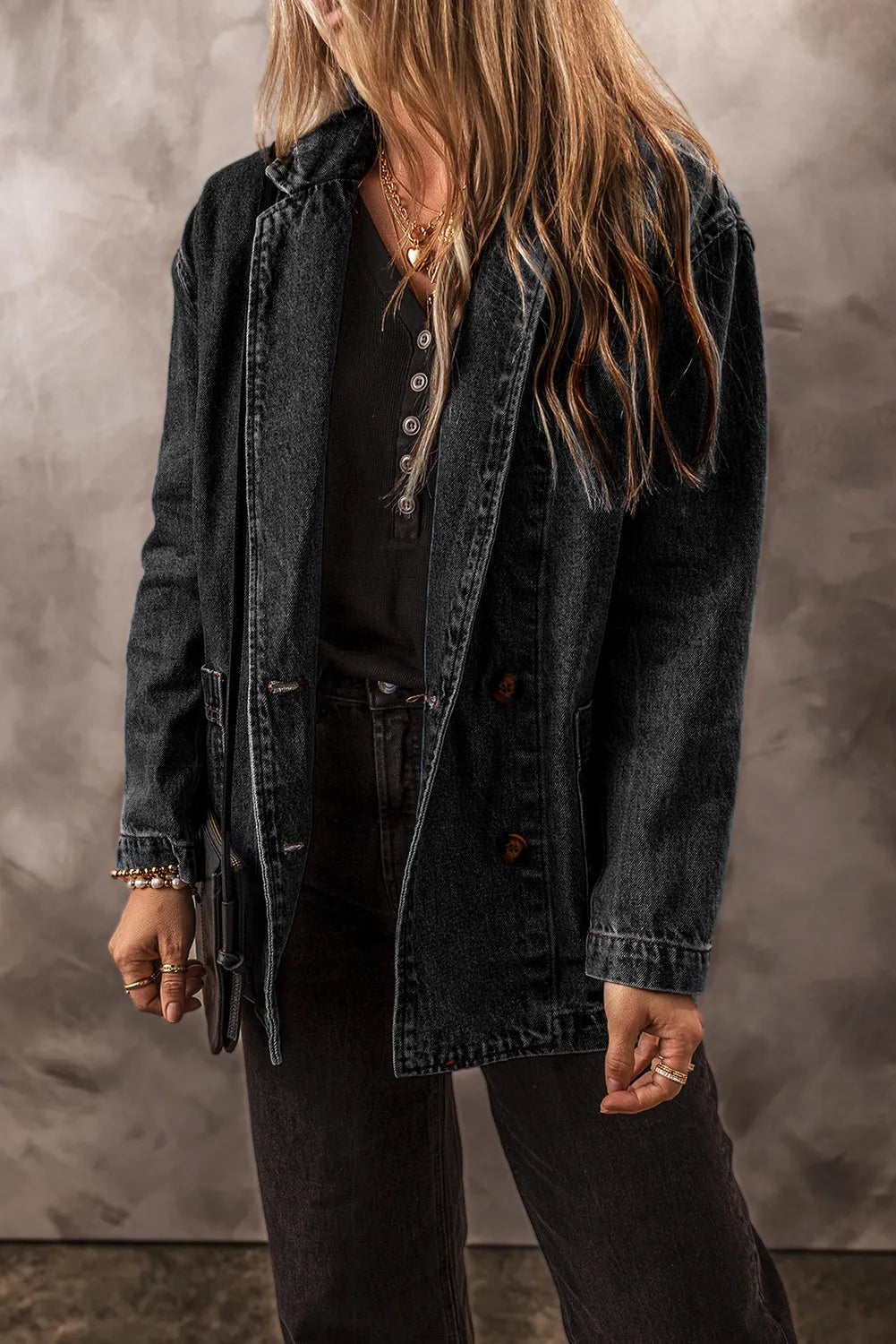 Dark wash denim double-breasted blazer with a notched lapel and button front closure.