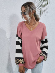 Blush pink waffle knit top with colorblock sleeves featuring black stripes and leopard print cuffs.