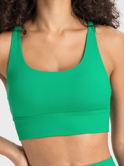 Green performance sports bra with scoop neck and crisscross back detail