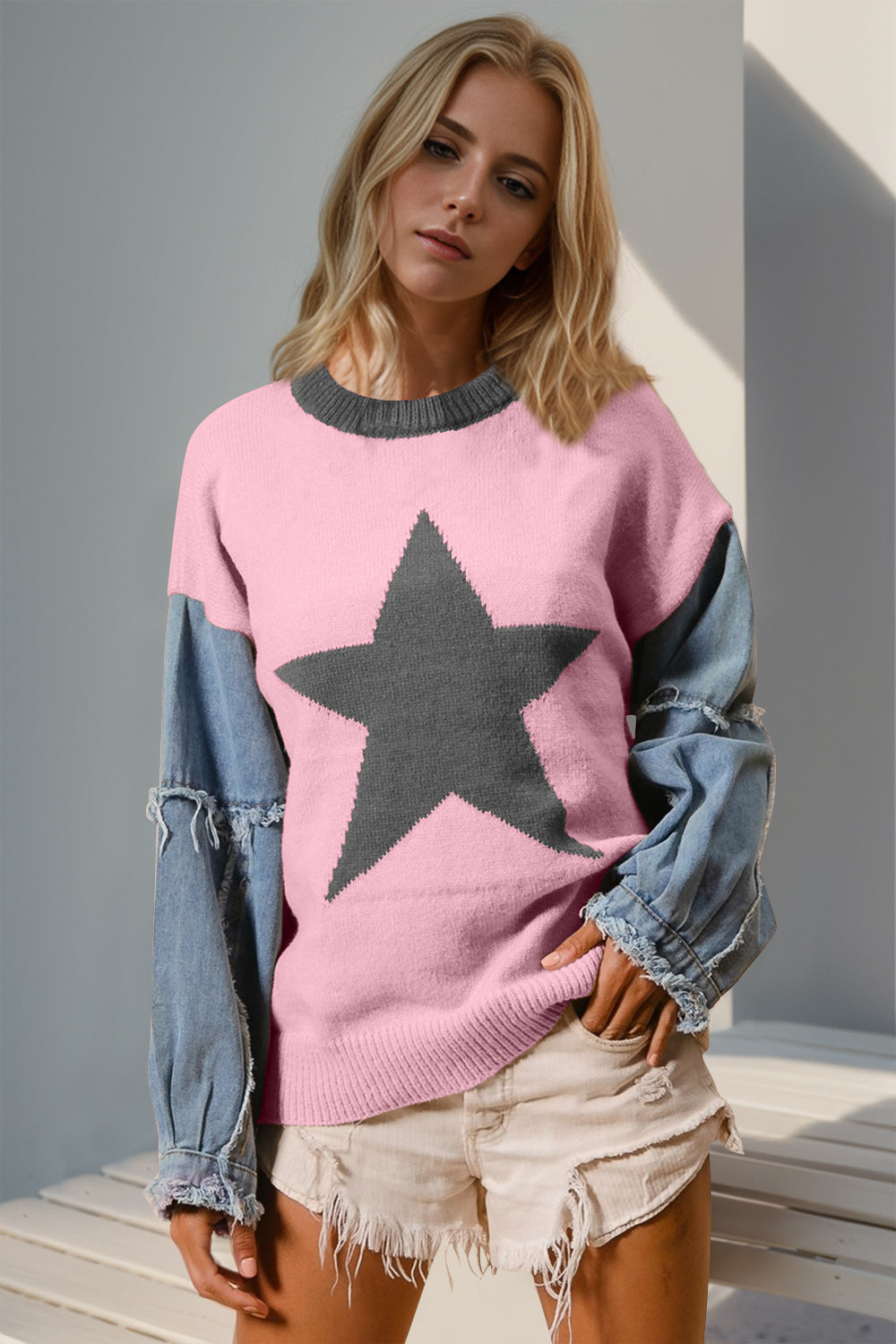 Blush pink knit sweater with gray star detail and denim sleeves.