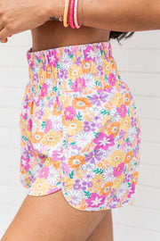 Floral print shorts with scalloped hem and elastic waist in blush pink.