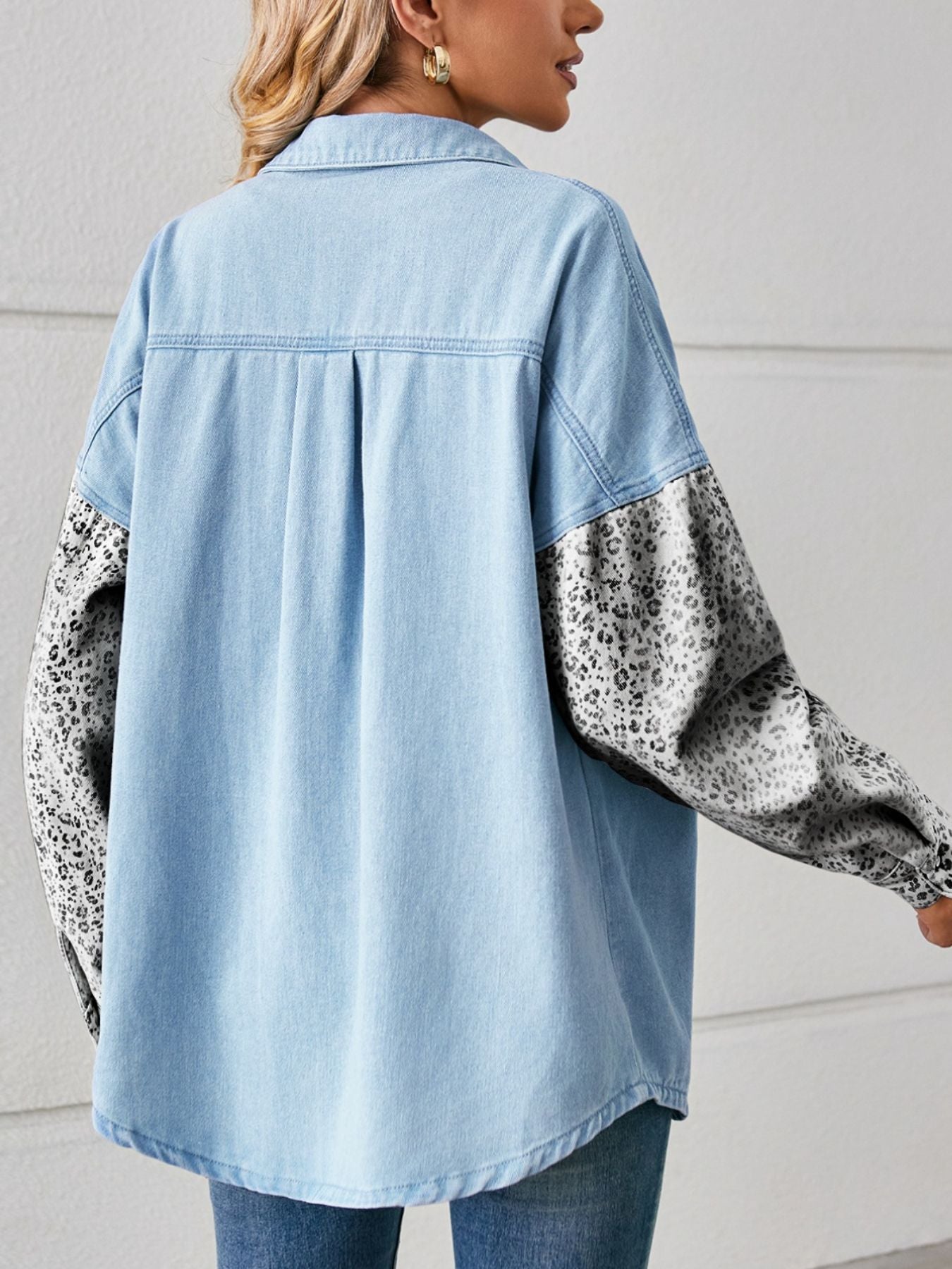 Light wash denim shirt with leopard print sleeves and button-up front.