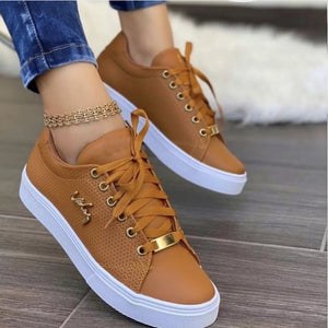 Brown perforated lace-up sneakers with gold accents and white soles.