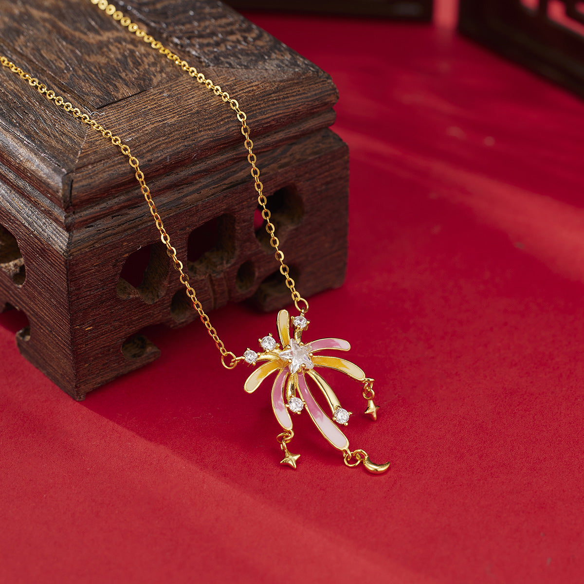 18k gold starburst pendant necklace with pink and yellow enamel and cubic zirconia accents.