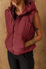 Burgundy quilted hooded puffer vest with drawcord detail and zip pockets.