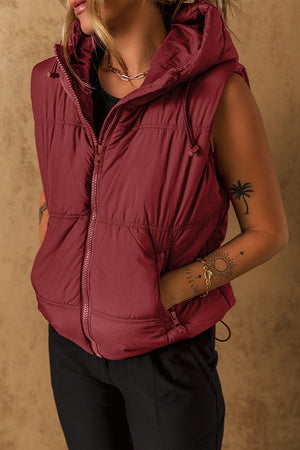 Burgundy quilted hooded puffer vest with drawcord detail and zip pockets.