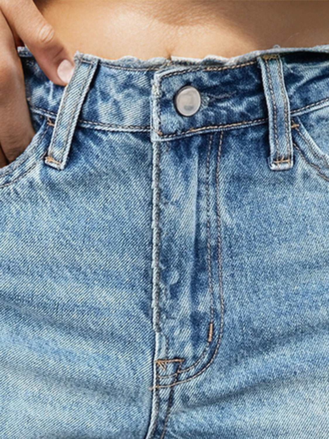Medium wash denim cutoff shorts with frayed hemline and button fly.