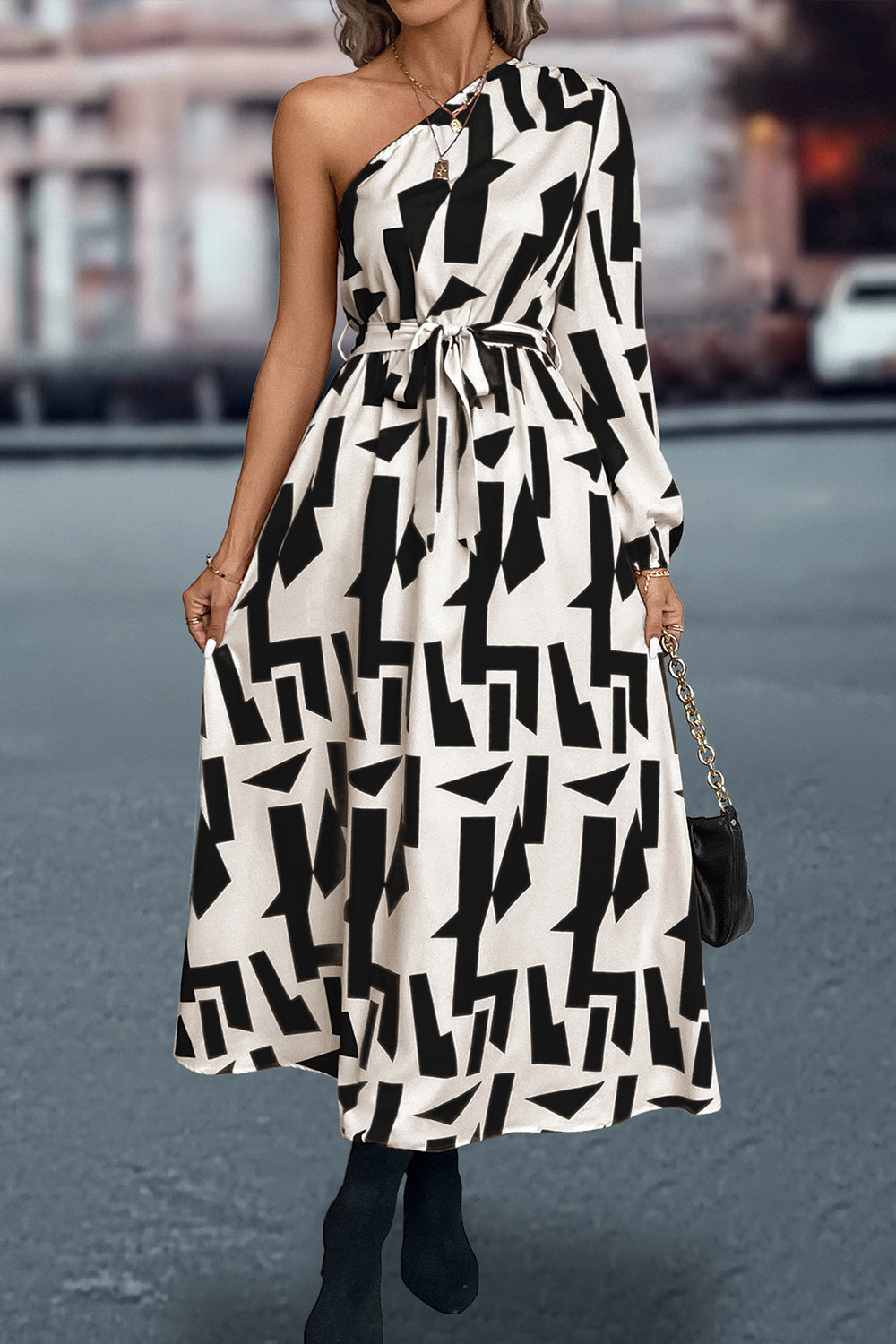 Black and white geometric print asymmetric maxi dress with belt and one long sleeve.