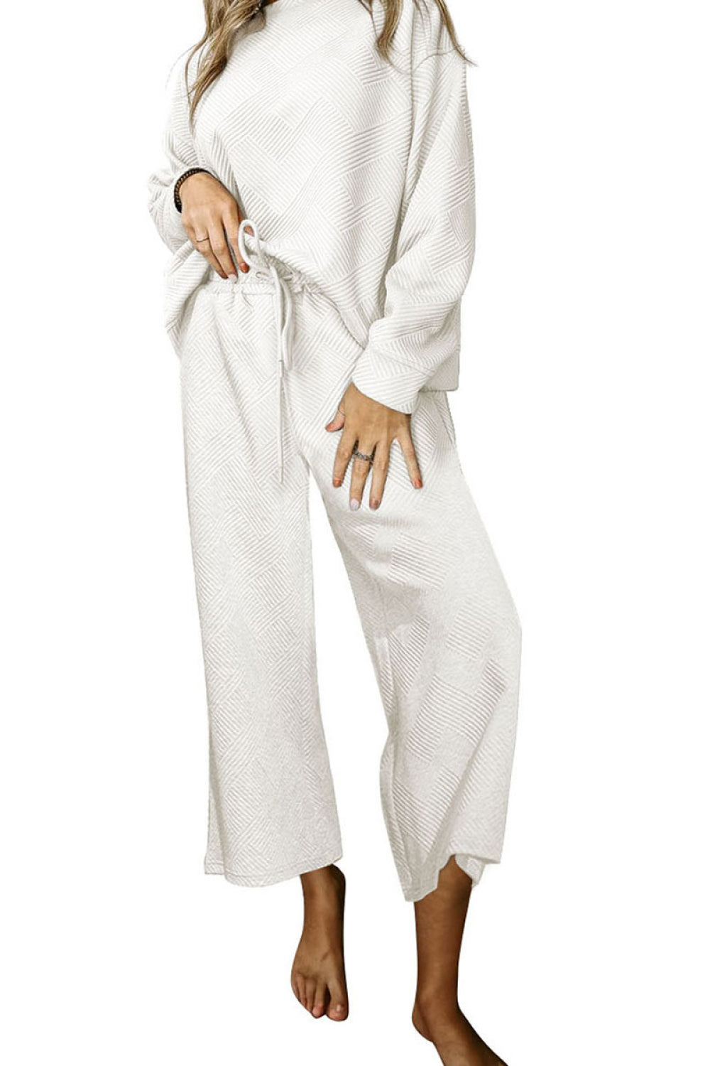 White loungewear set with textured pattern, crew neck top and wide leg pants.