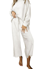 White loungewear set with textured pattern, crew neck top and wide leg pants.