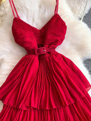 Red belted pleated midi dress with spaghetti straps and a buckle.