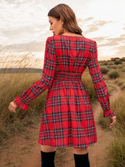 Red plaid mini dress with smocked waist and ruffled cuffs.