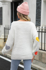 White fluffy knit sweater with heart patches on sleeves, crew neck, long sleeves.