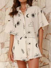 Beige linen romper with celestial print, buttoned collar, and flared hem.