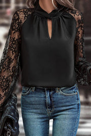 Black blouse with keyhole neckline and lace sleeves.