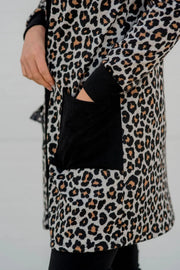 Leopard print cardigan with black trim and pockets.