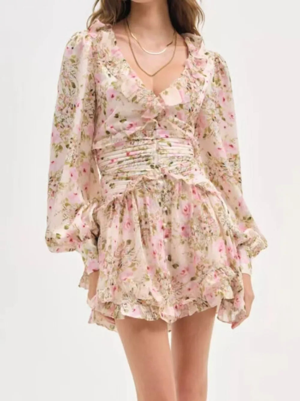 Charming floral mini dress with ruffles, ruched waist, and long puff sleeves.