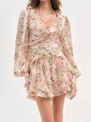 Charming floral mini dress with ruffles, ruched waist, and long puff sleeves.