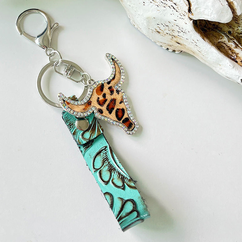 Embossed leather & crystal bull keychain with leopard print detail and turquoise strap.