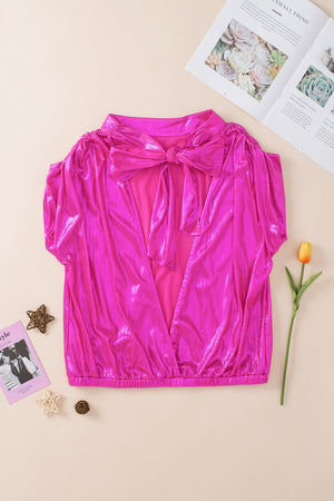 Hot pink metallic cap-sleeve blouse with a large bow detail and open back.