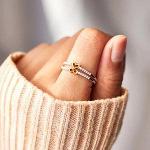 Double band ring with heart and infinity symbols, adorned with cubic zirconia stones.