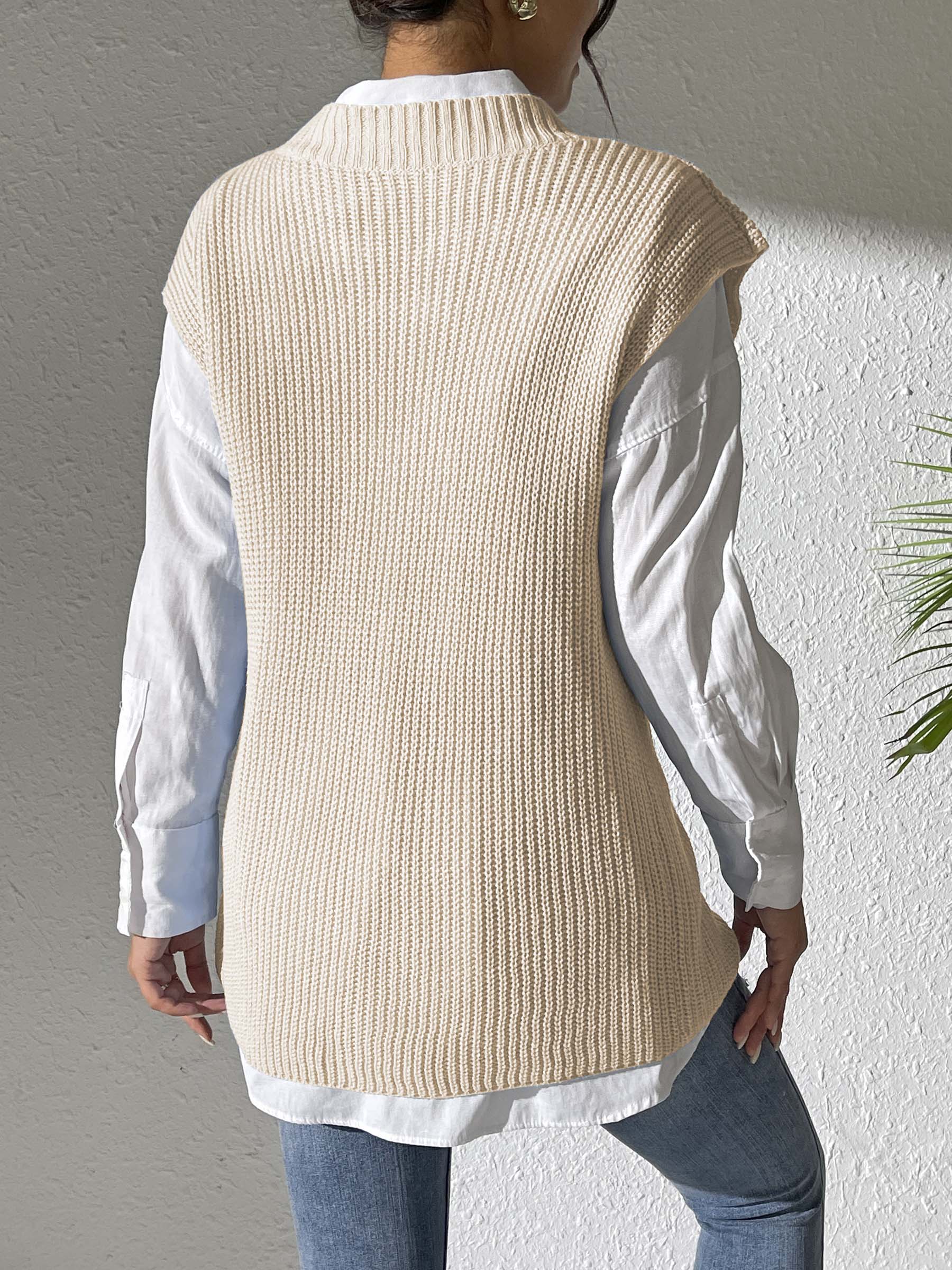 Beige ribbed knit sleeveless vest with mock neck over white shirt