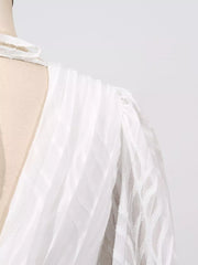 White maxi dress with textured fabric and balloon sleeves