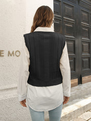 Black cable knit crop vest sweater with ribbed trim, worn over a white shirt.
