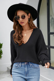 Black textured knit pullover sweater with deep V-neck and long sleeves.