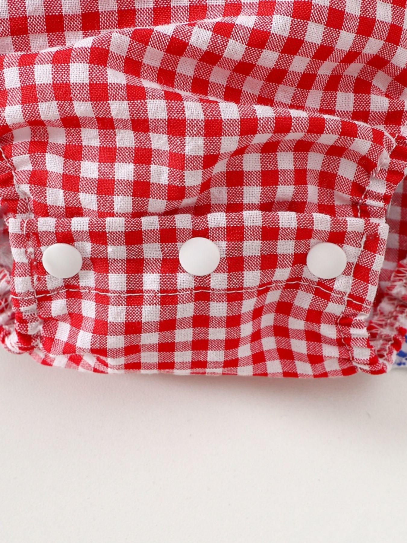 Red and white gingham baby dress with ruffled trim and white buttons