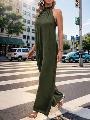 Dark green halter neck wide leg jumpsuit with backless detail.