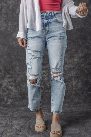 Distressed wash light denim slim leg jeans with ripped details