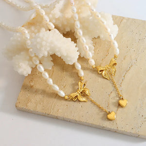 Gold pearl necklace with bow and heart drop charms