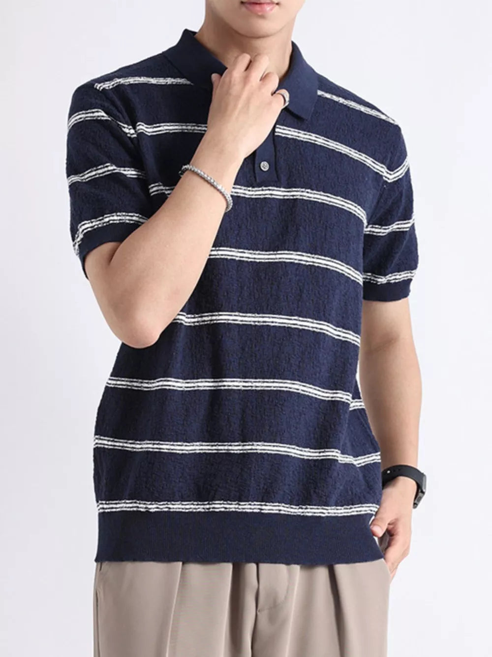 Navy blue striped knit polo shirt with button accents and short sleeves.