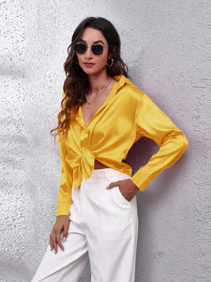 Gold silken button-down shirt with a knotted front and collared neckline.
