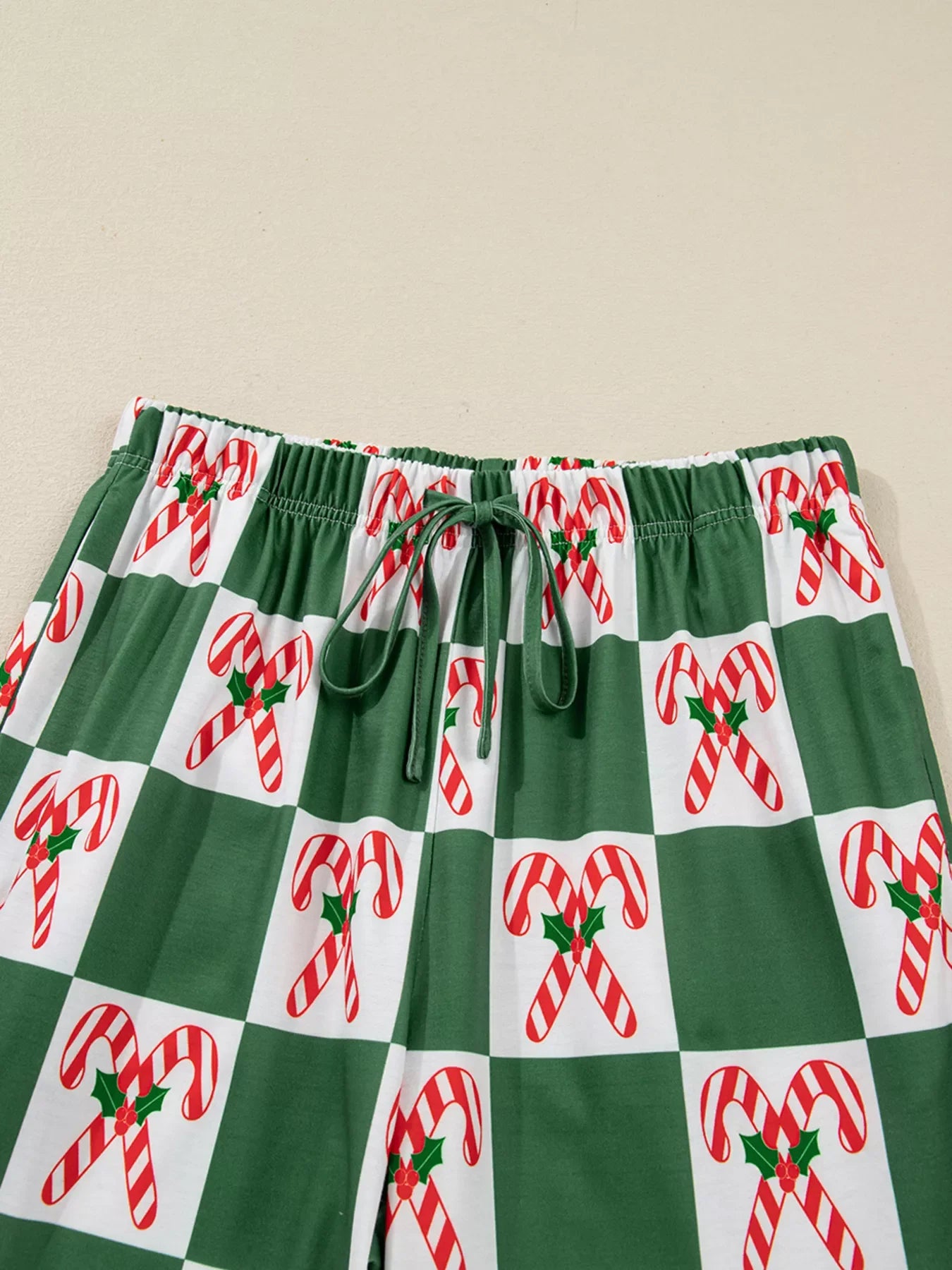 Green checkered pajama pants with candy cane print and drawstring waist