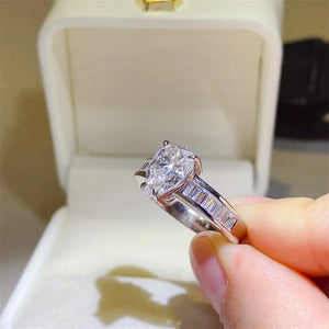 Silver pear cut moissanite ring with baguette accents on band