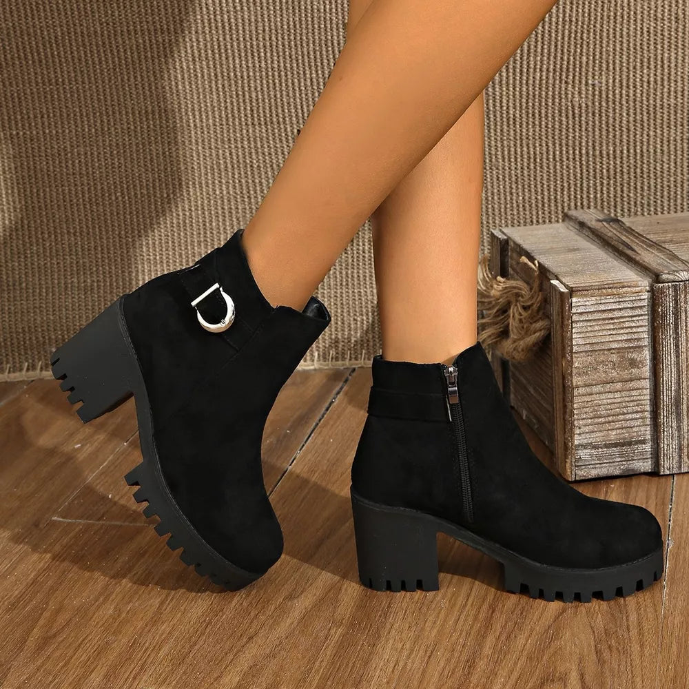 Black suede round toe ankle boots with block heel and decorative buckle detail.
