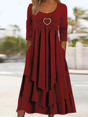 Wine red tiered midi dress with long sleeves, scoop neck, and heart detail.