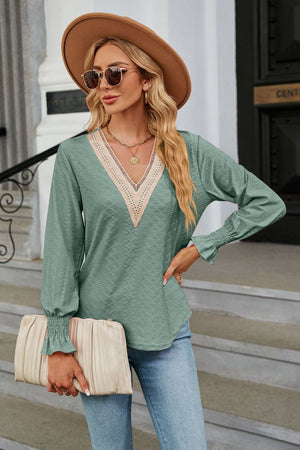 Sage green textured V-neck blouse with lace trim and ruched cuffs