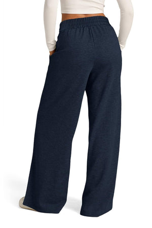 Navy seamed palazzo lounge trousers with elastic waist and pockets, styled casually.