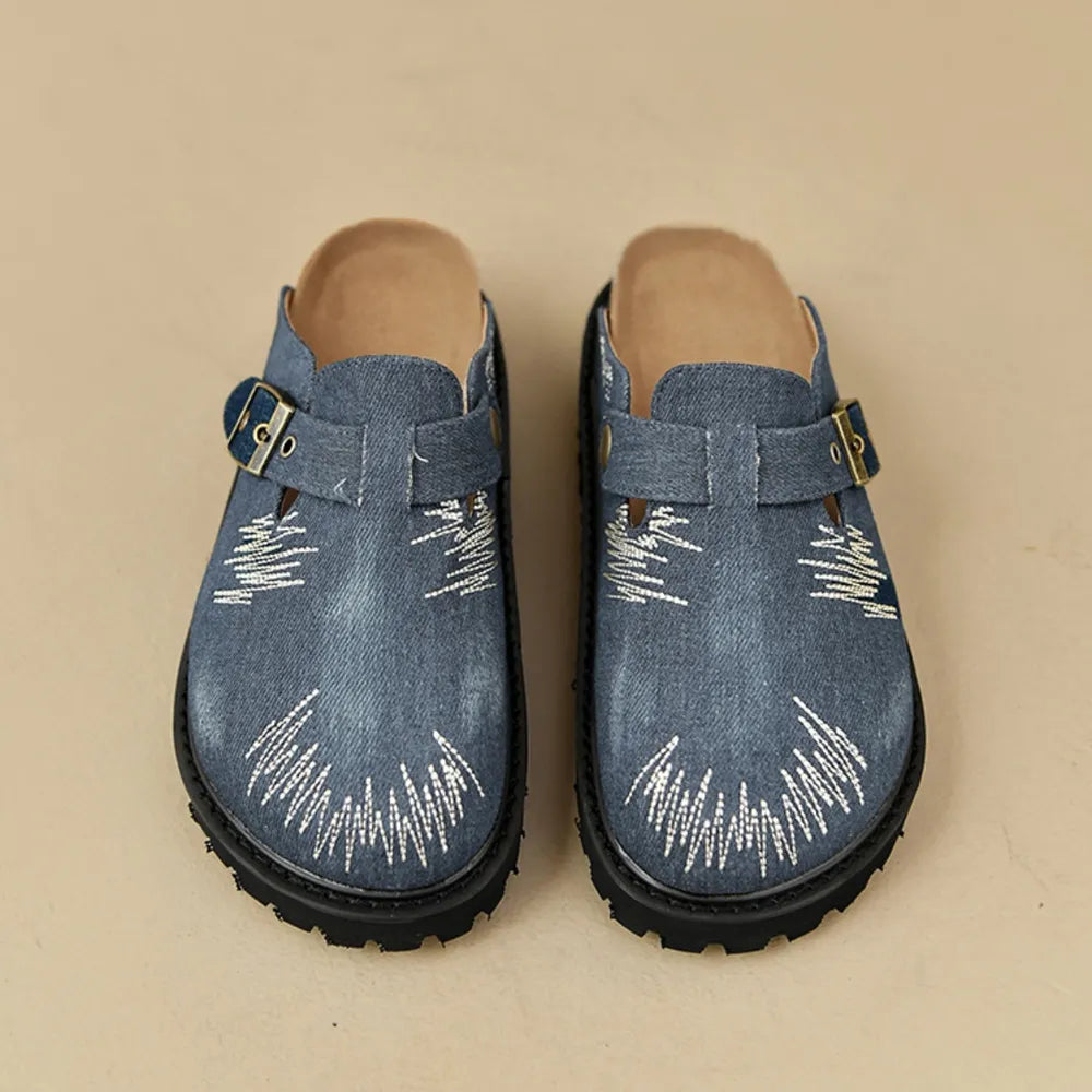 Embroidered denim platform clogs with buckle strap detail.