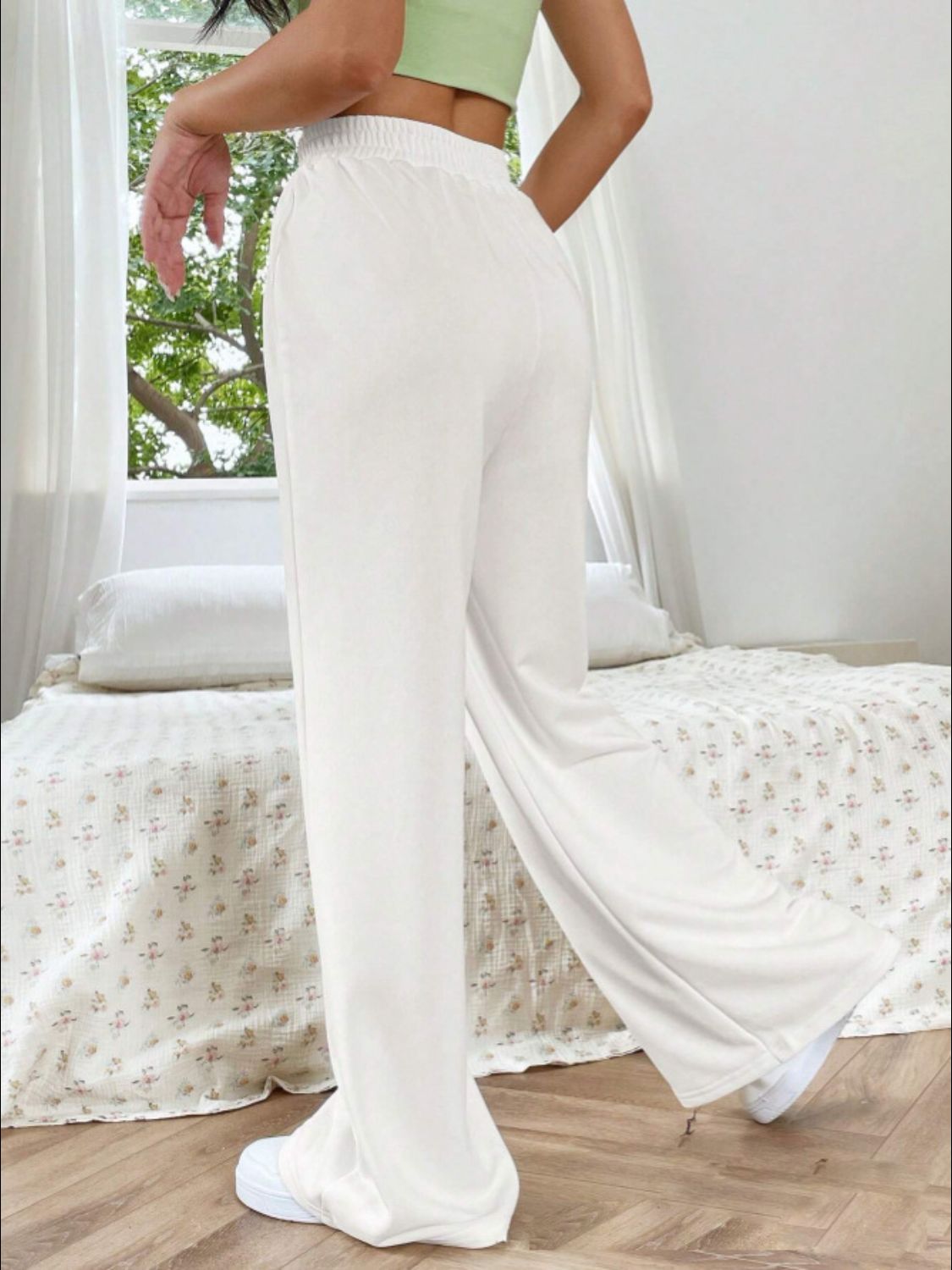 White V-waistline palazzo sweatpants with center seams and wide legs.