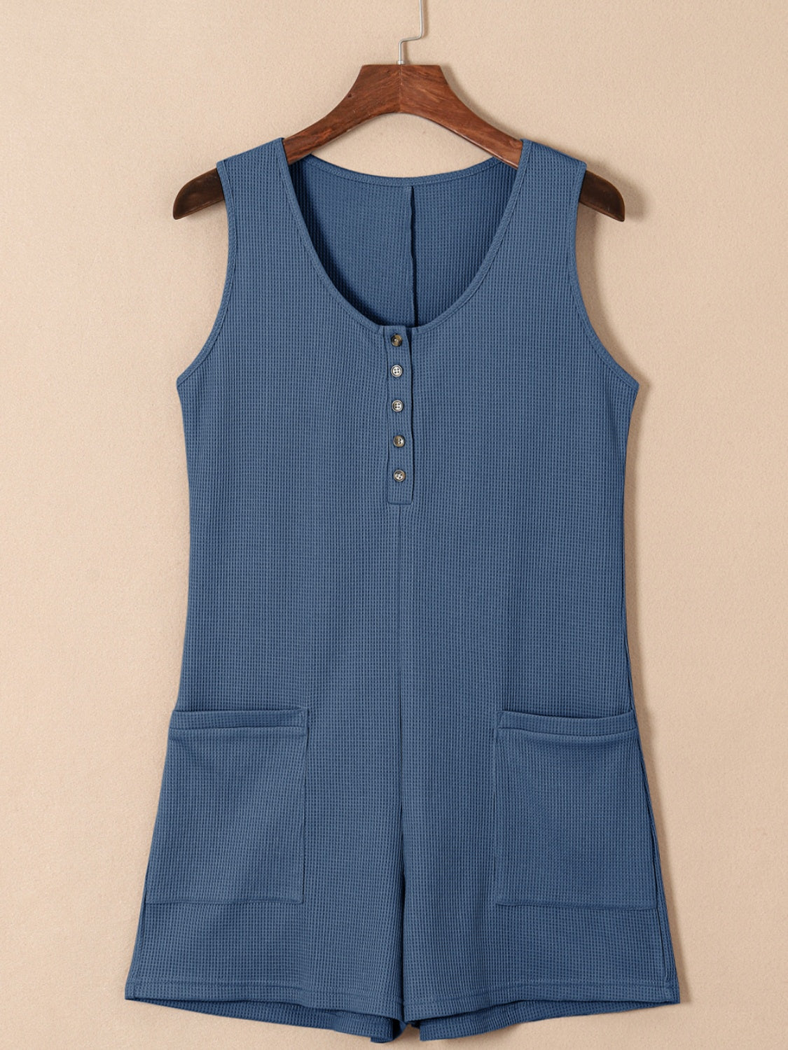 Dusty Blue waffle knit button-down romper with pockets and a scoop neckline.