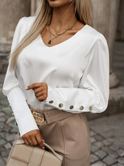 White blouson sleeve v-neck top with button cuffs and a relaxed fit.